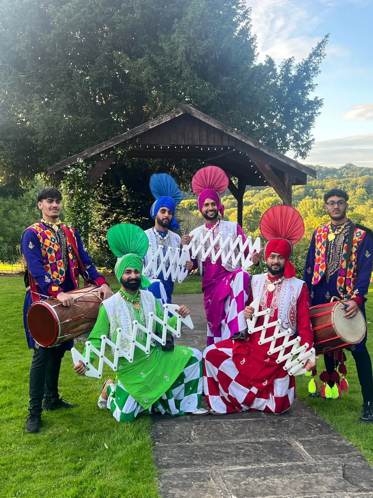 Bhangra dancers with dhol players in colourful outfits outdoors