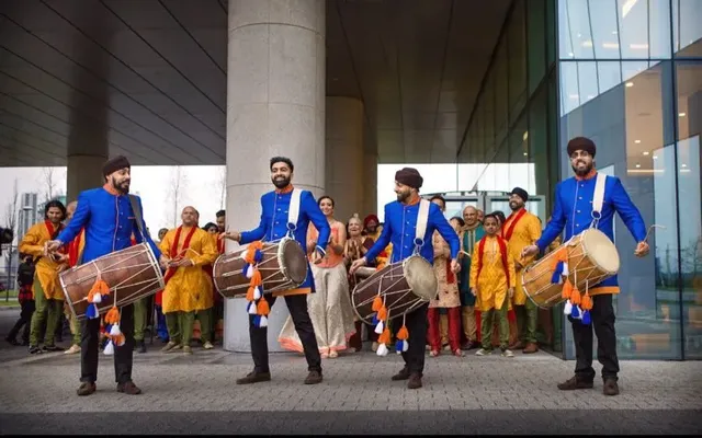 Dhol team performing at a baraat outside a London hotel