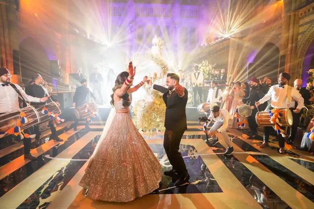 Bride and groom dancing with dhol players at the Natural History Museum, London