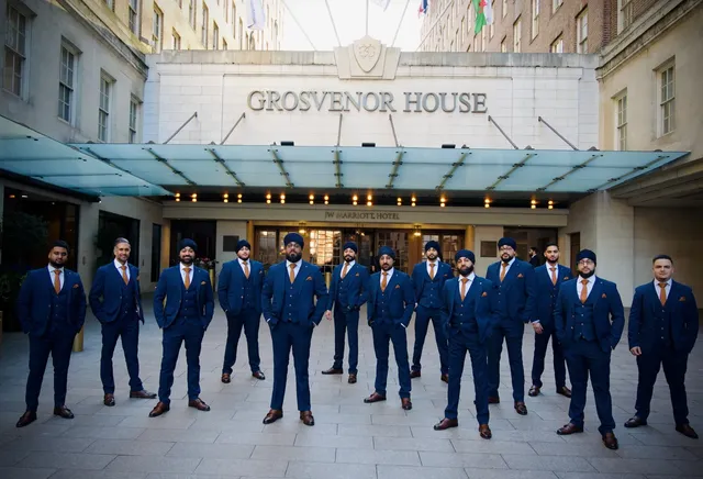 Dhol team in matching suits outside Grosvenor House, London