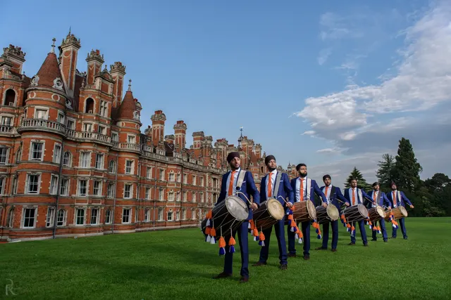 Dhol team lined up on the lawn at Royal Holloway, Egham