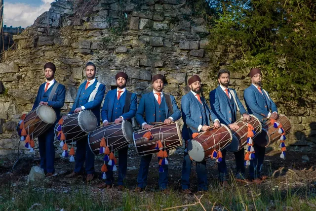 Dhol team in blue sherwanis at the ruins in Virginia Water