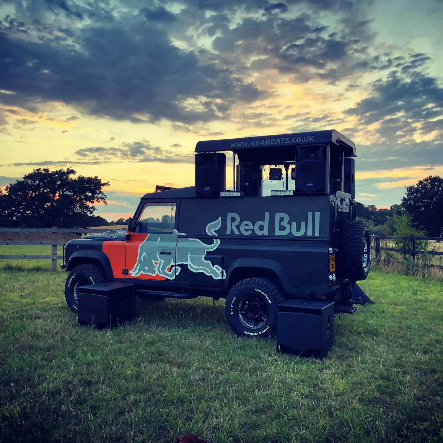 Branded DJ truck parked on grass at sunset