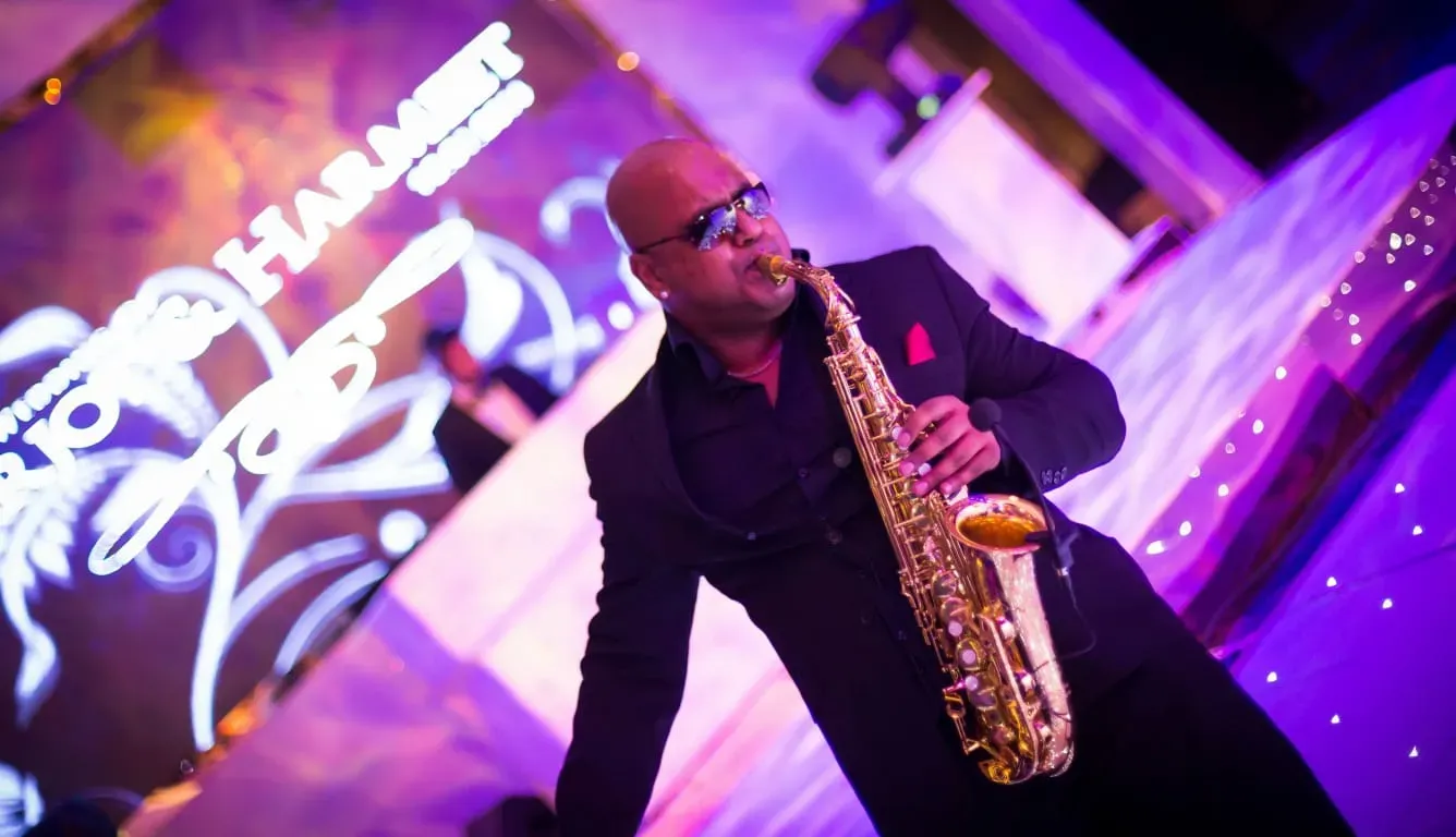 Saxophonist performing under purple party lighting