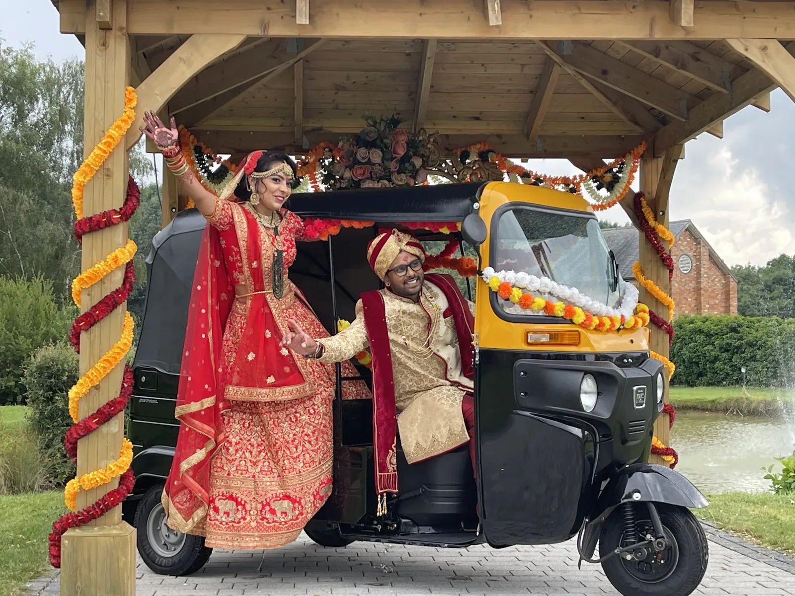 Bride and groom with a tuk tuk dressed in marigold garlands
