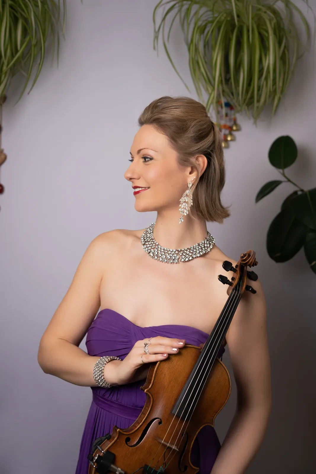 Violinist in a purple gown holding her violin