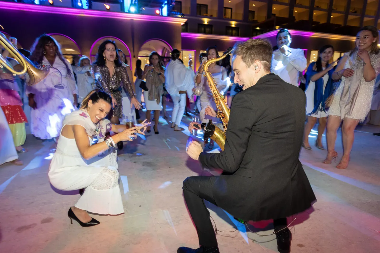 Sax player dancing with guests on the dancefloor