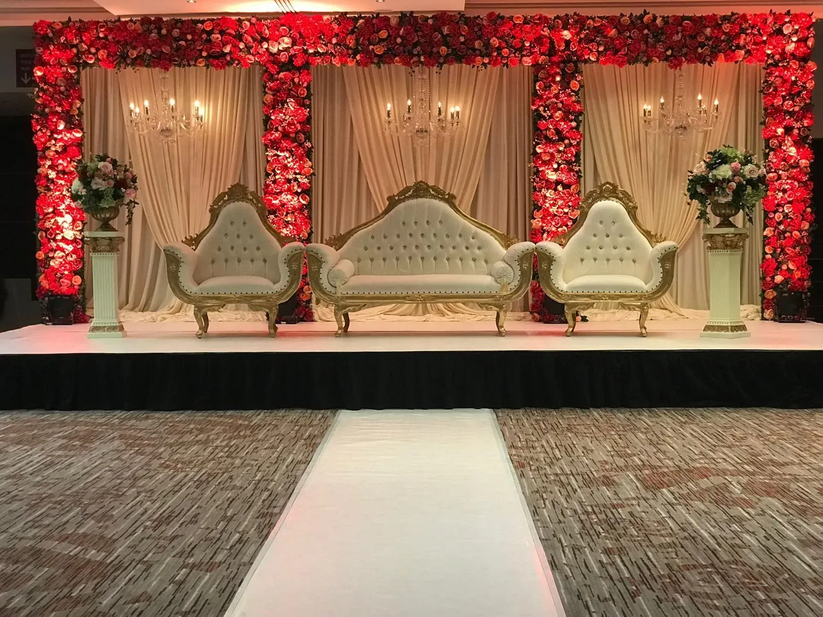 Red floral stage with a white aisle