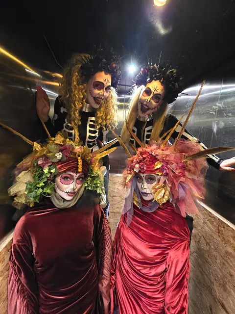 Floral venetians day of the dead with stilt skeletons: living statues