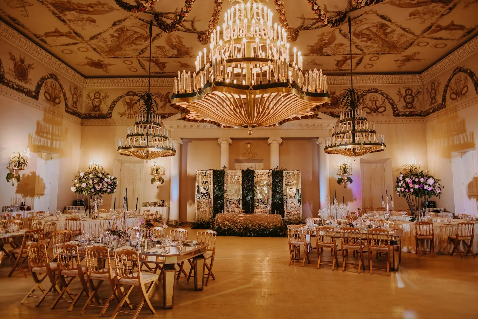 A grand ballroom with chandeliers, set for a wedding reception