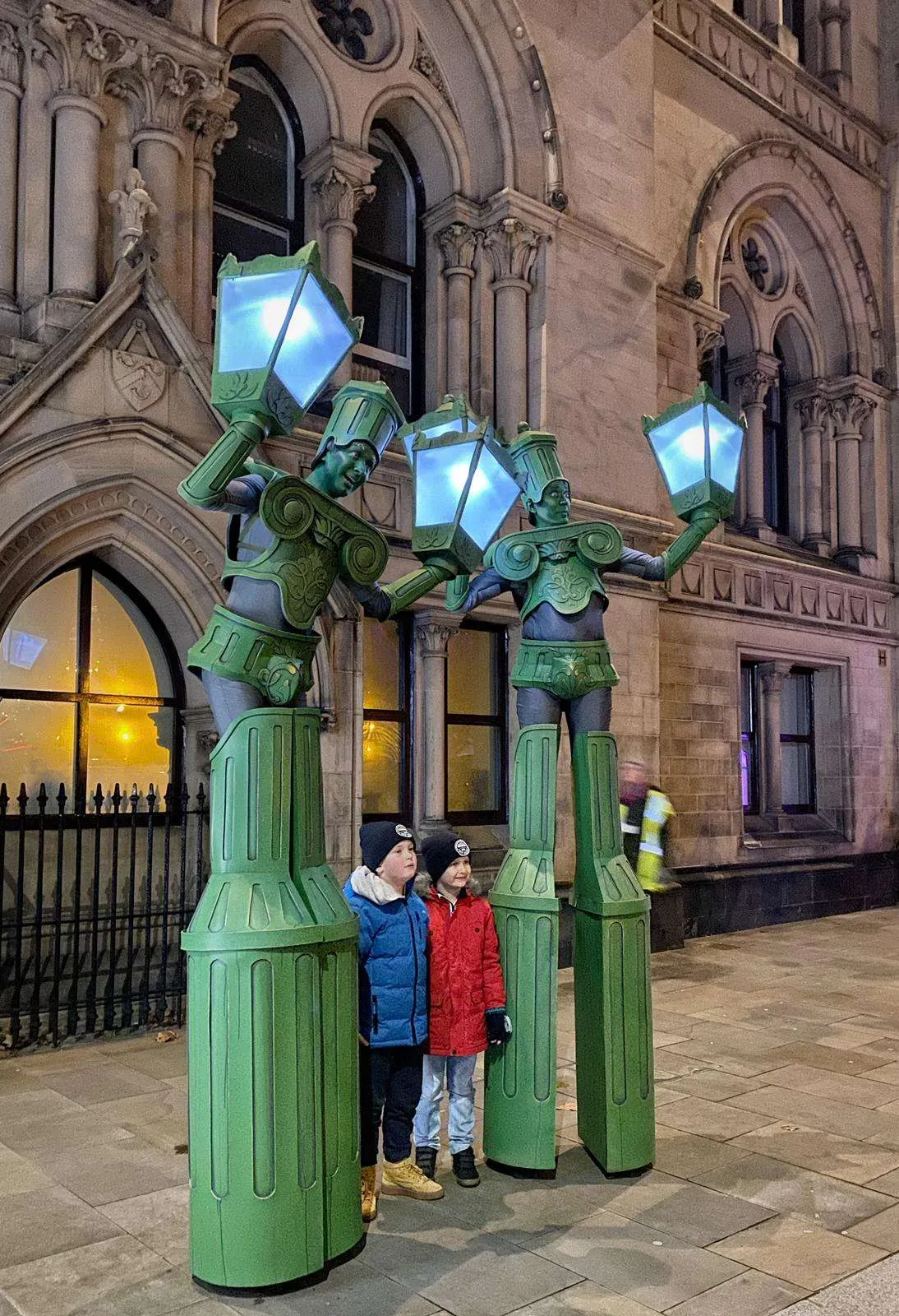 Stilt walkers costumed as glowing Victorian lamp posts in a winter themed set